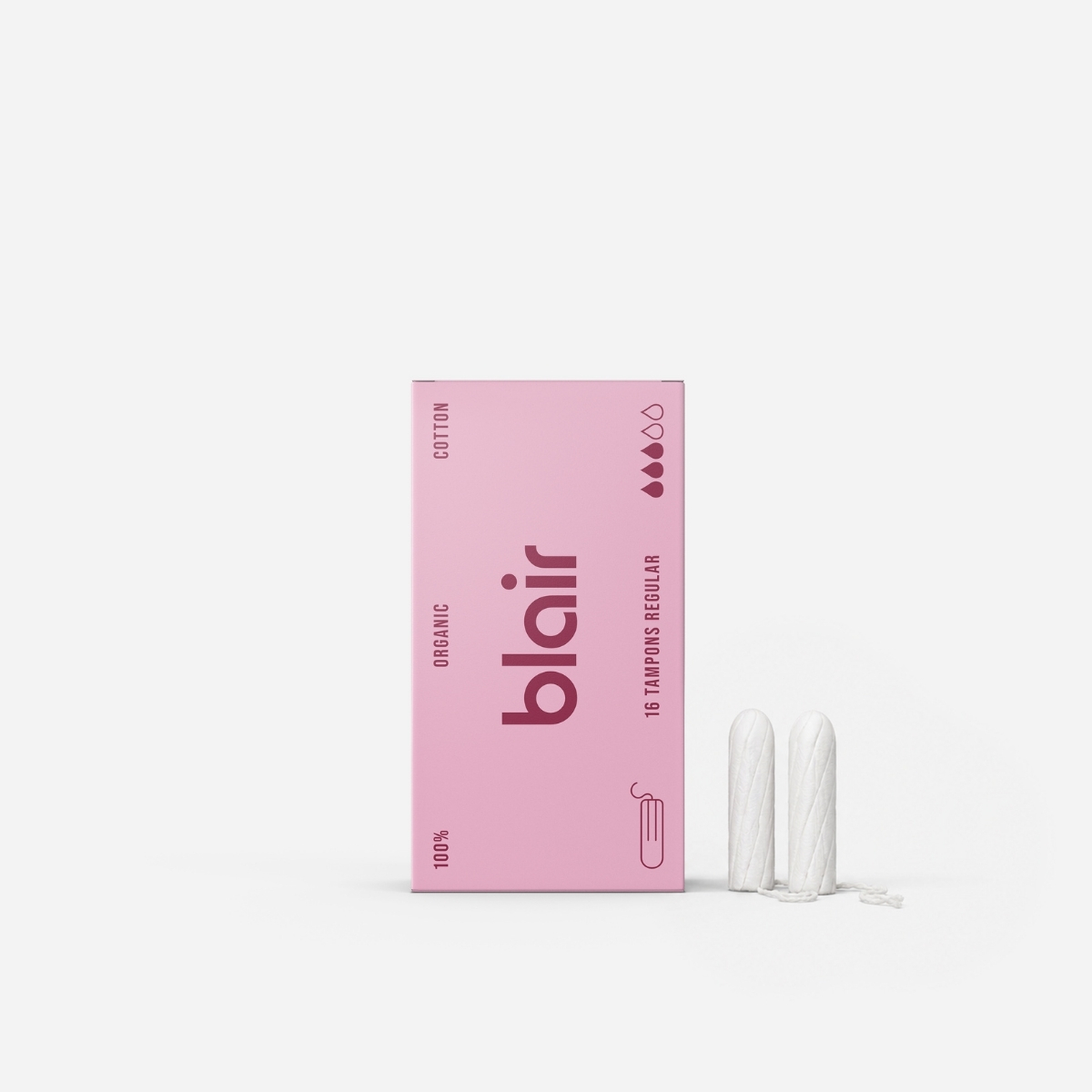 En Blair-förpackning med tamponger på en grå bakgrund med två tamponger i bomull vid sidan