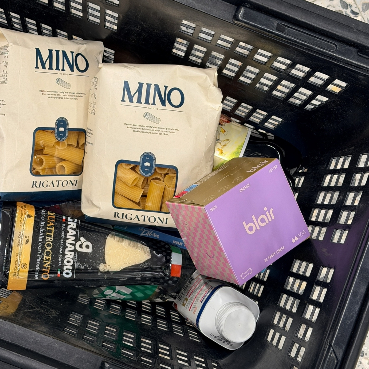 Ett lila paket med Blair trosskydd i en varukorg med pasta och parmesan