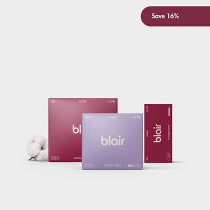 Tre Blair-förpackningar med bindor, trosskydd och tamponger på en grå bakgrund med bomull vid sidan