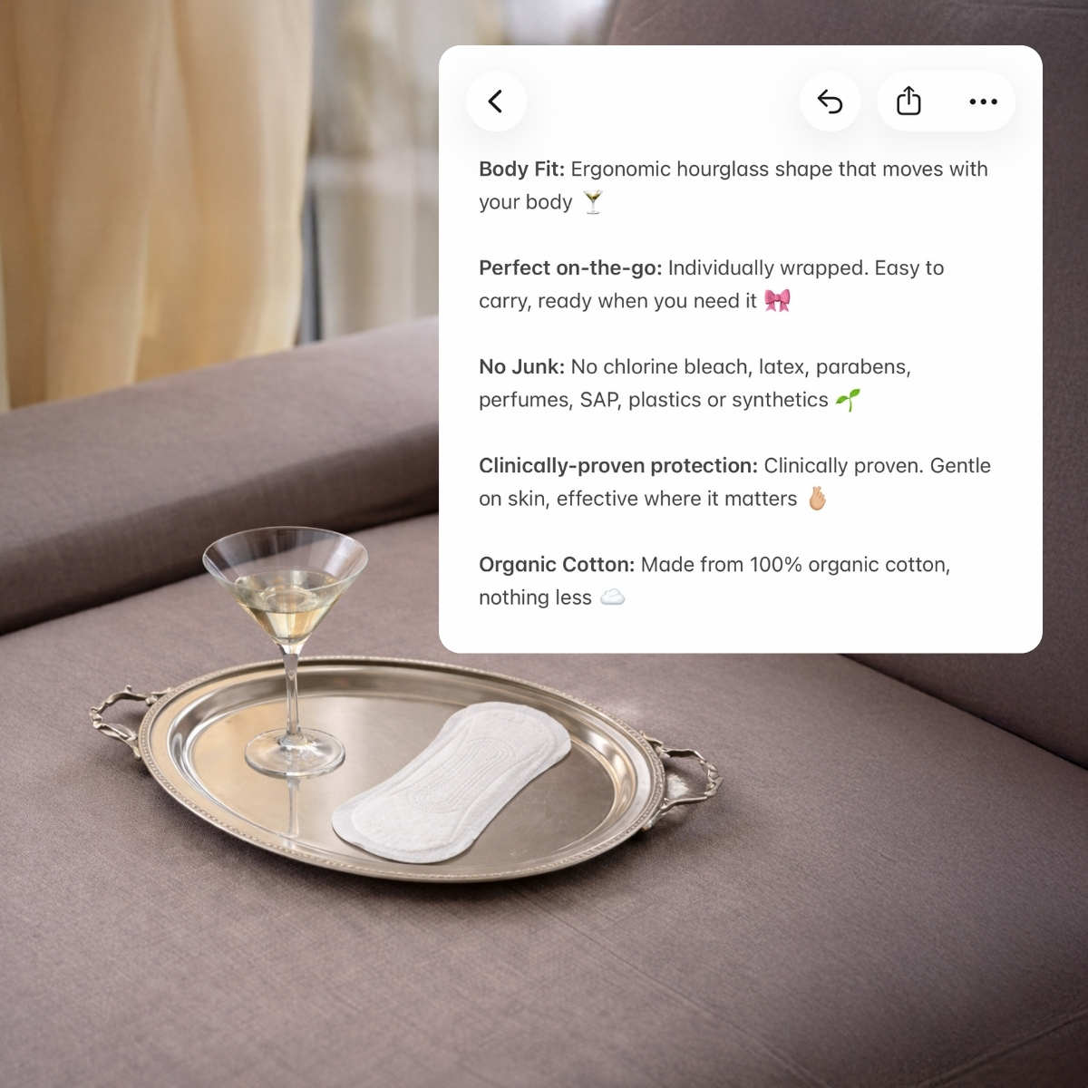 Ett trosskydd och ett martiniglas på en silverbricka på en beige soffa