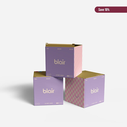 Tre Blair-förpackningar med bindor, trosskydd och tamponger på en grå bakgrund med bomull vid sidan