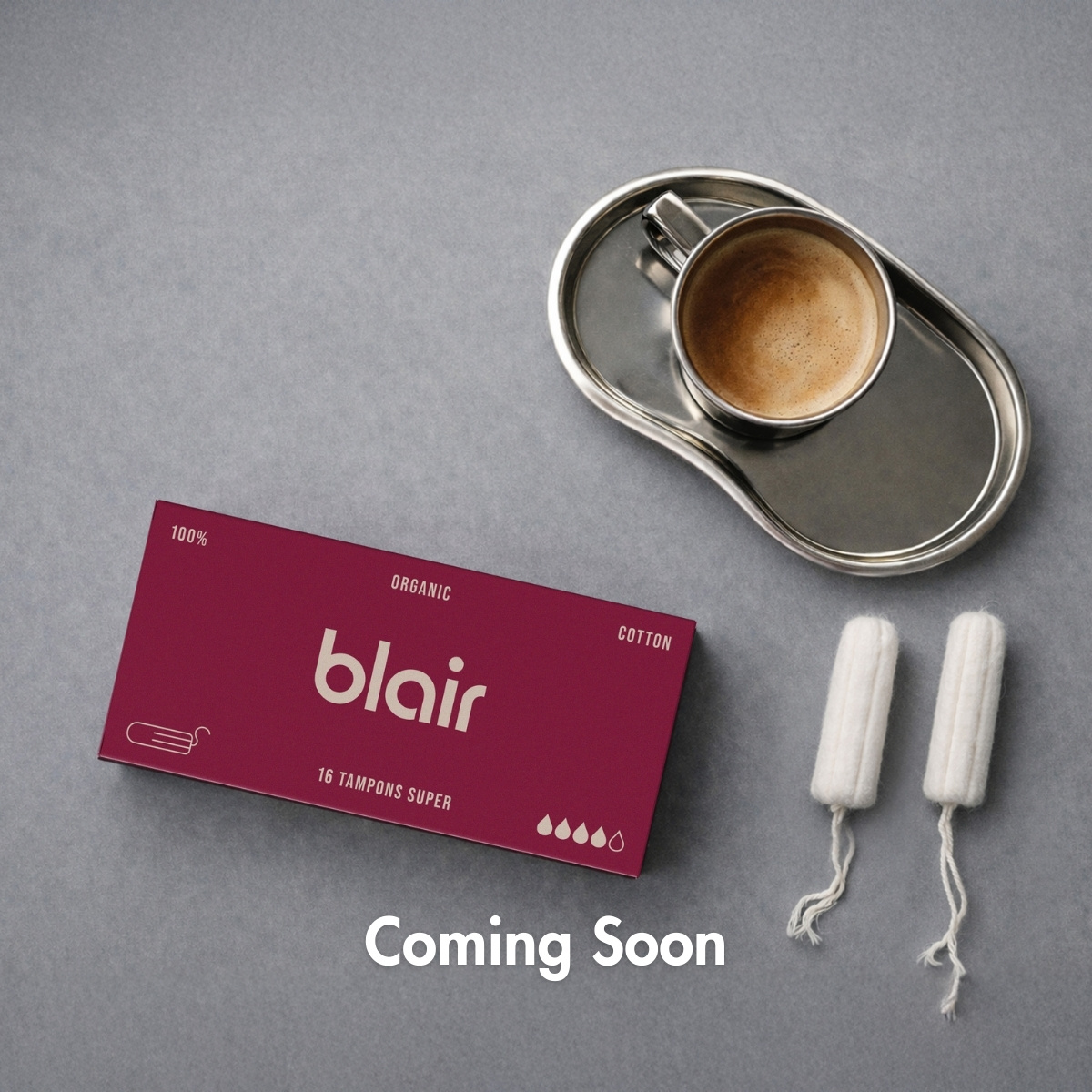 A red Blair-package for tampons with a cup of coffee on a grey background