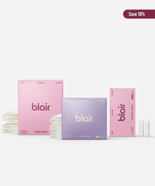 Tre Blair-förpackningar med bindor, trosskydd och tamponger på en grå bakgrund