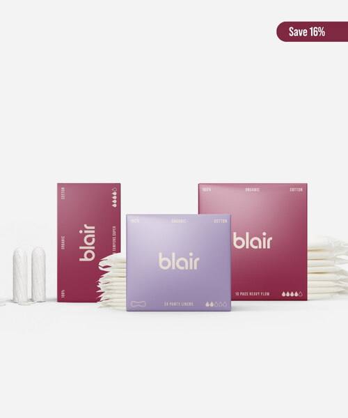 Tre Blair-förpackningar med bindor, trosskydd och tamponger på en grå bakgrund