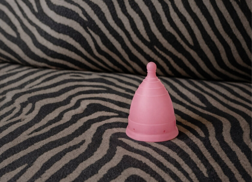 En rosa menskopp på en soffa i zebratyg
