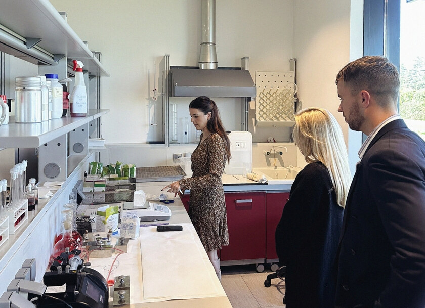 Tre personer i en fabrik som diskuterar olika mensskydd