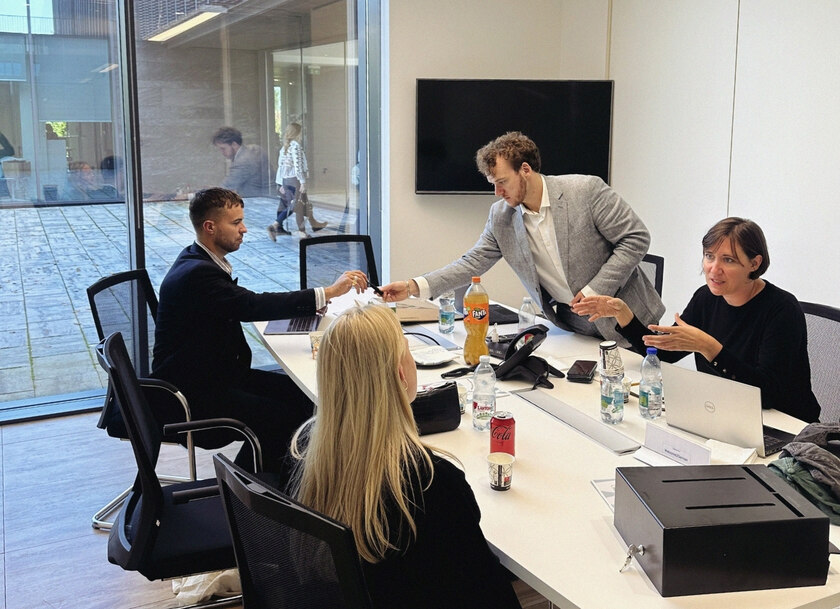 Fyra personer runt ett vitt bord som pratar